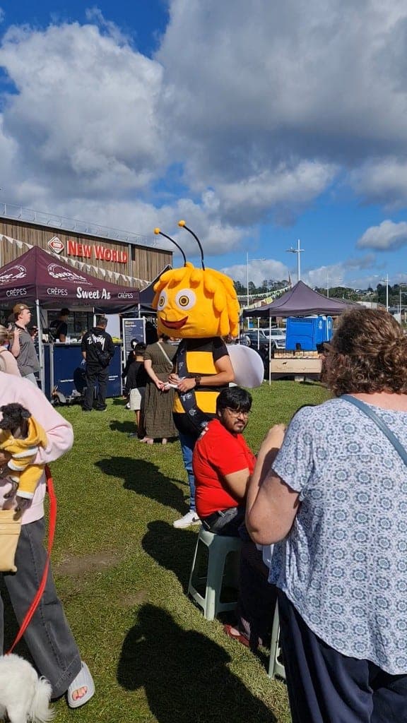 Visitors walking through the Long Bay farmers market on a sunny day